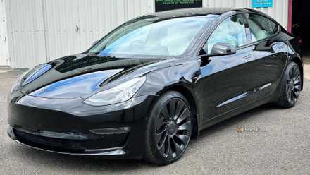 the Tesla Top rate Connectivity selection Static front 3/4 shot of a black 2021 Tesla Model 3 Performance.