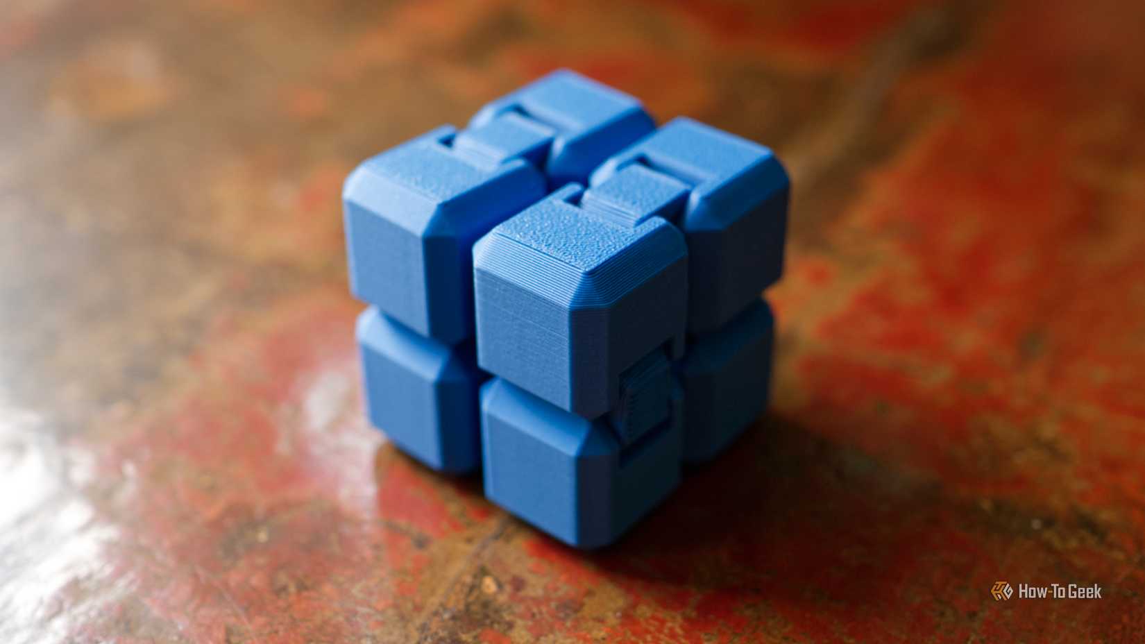 3D printed infinity cube on a wooden surface.