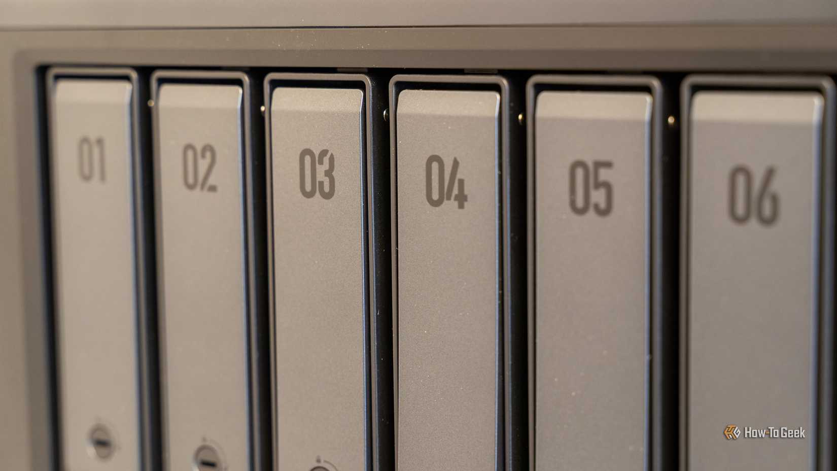 A close-up of the six numbered drive bay covers on the Ugreen iDX6011 Pro NAS.