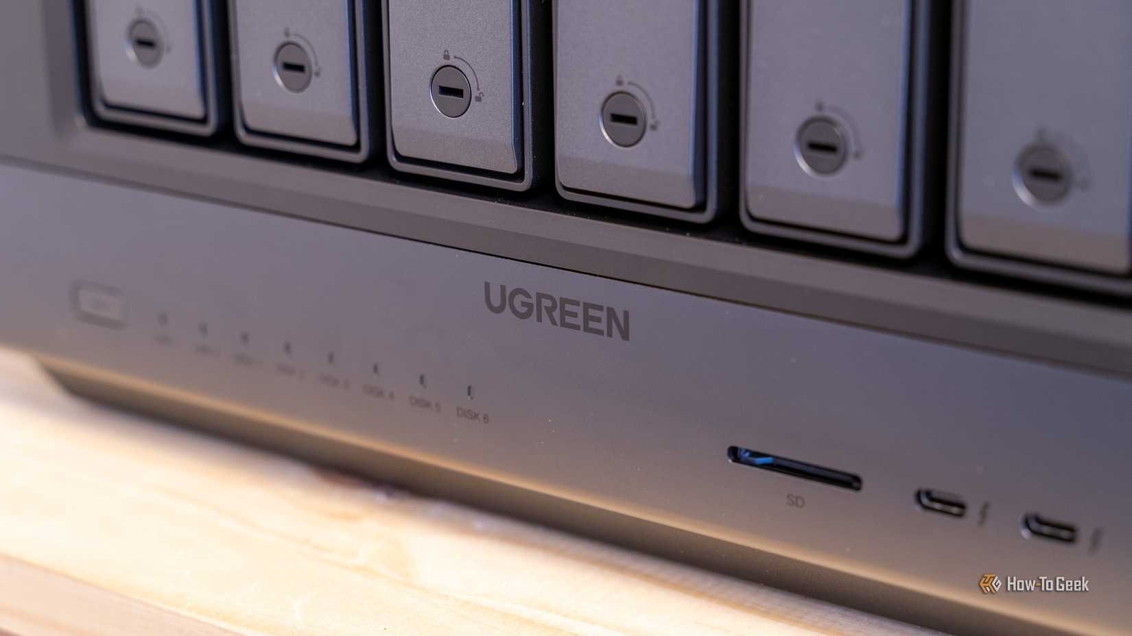 A close-up of the Ugreen iDX6011 Pro NAS front panel showing drive bay locks, status LEDs, and SD card slot.