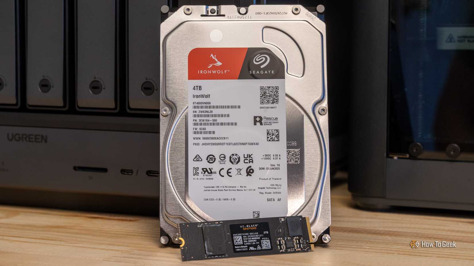 A Seagate IronWolf 4TB hard drive and a WD Black NVMe SSD side by side in front of the Ugreen iDX6011 Pro NAS.