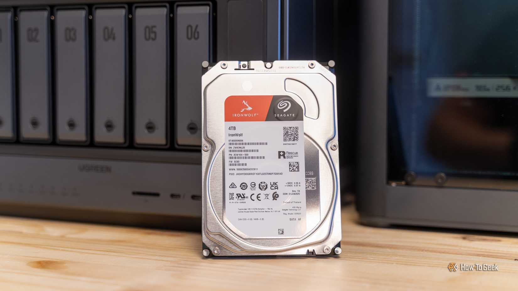 Ugreen iDX6011 Pro NAS এর সামনে পার্ক করা Seagate IronWolf 4TB হার্ড ড্রাইভের একটি প্রশস্ত শট।