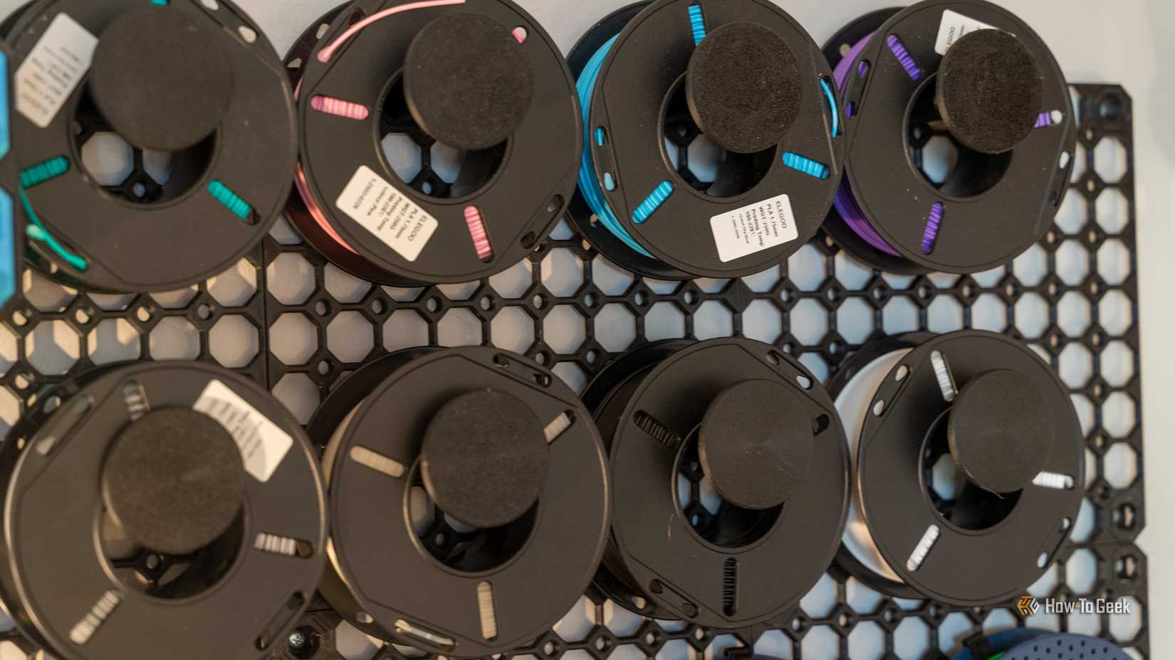 Rolls of filament hanging on a MultiBoard wall showing various colors and materials.
