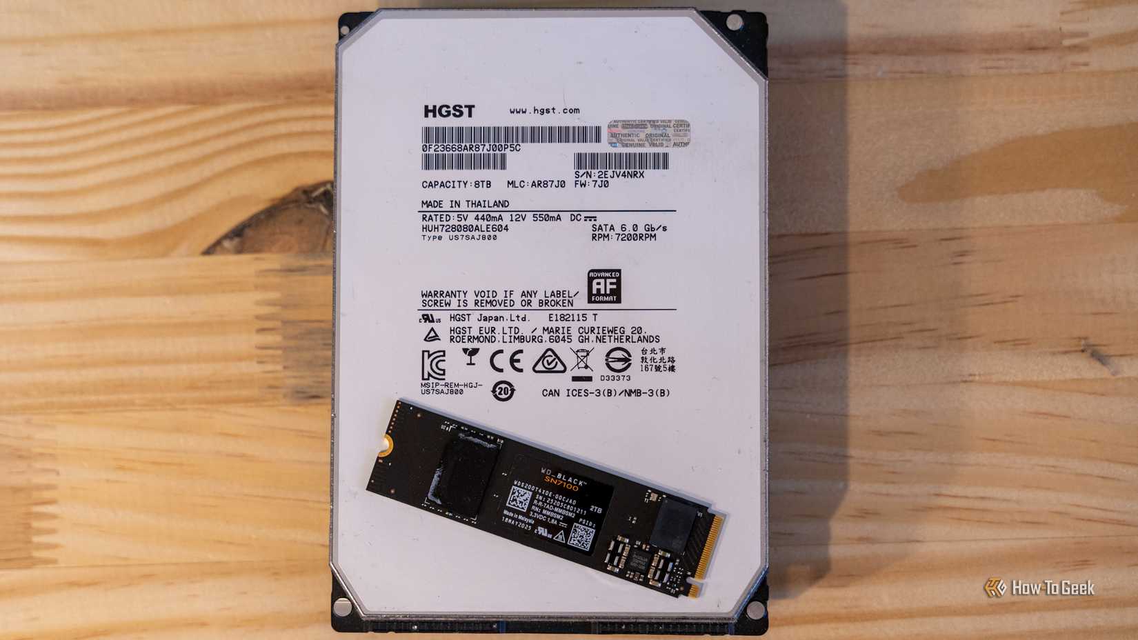 An 8TB HGST hard drive with a 2TB WD_BLACK NVMe SSD sitting on top of it.