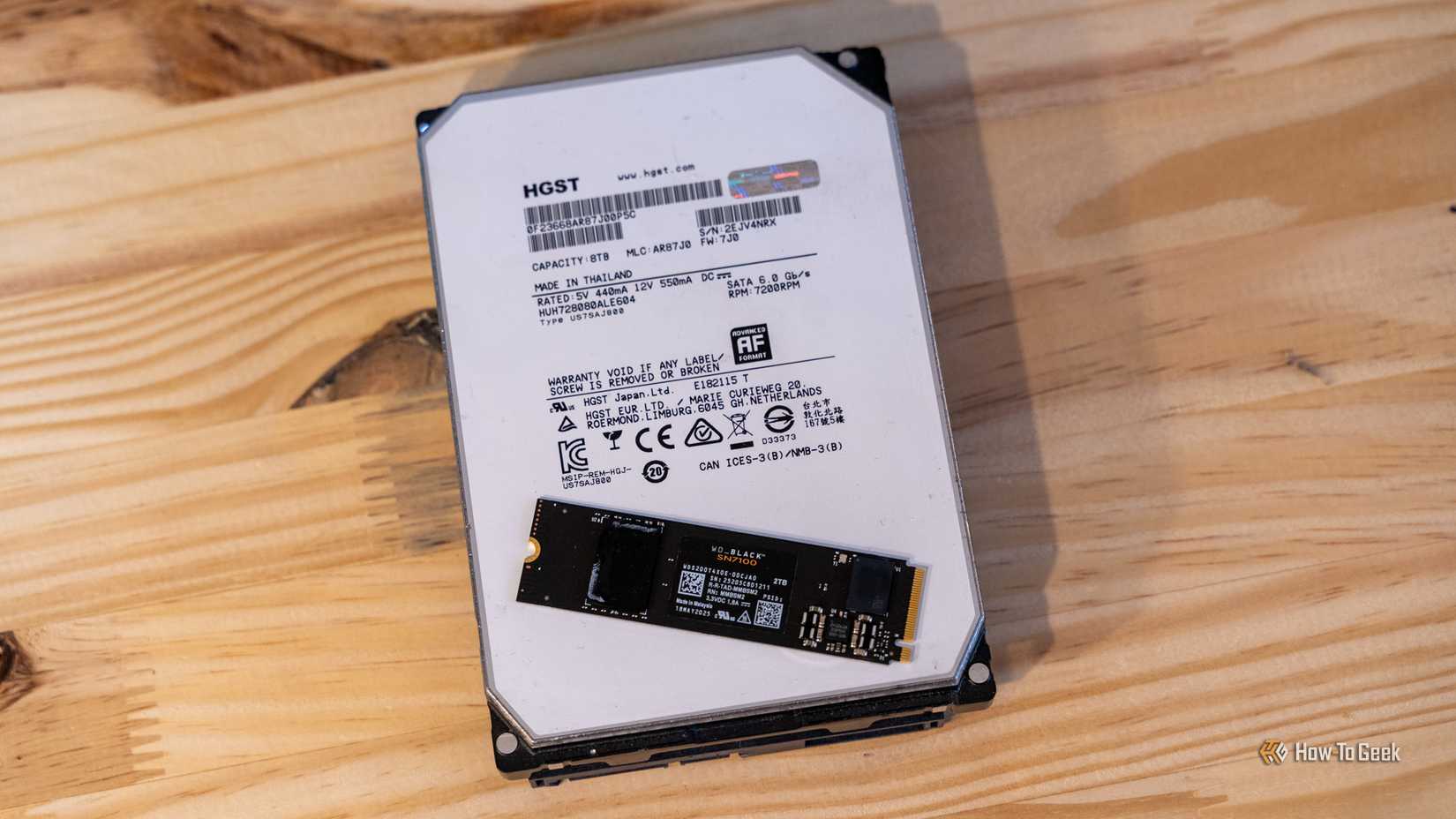 An 8TB HGST hard drive with a 2TB WD_BLACK NVMe SSD sitting on top of it.