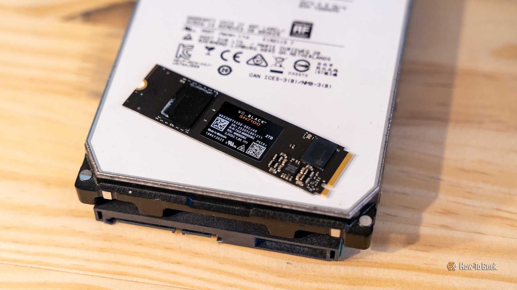 An 8TB HGST hard drive with a 2TB WD_BLACK NVMe SSD sitting on top of it.