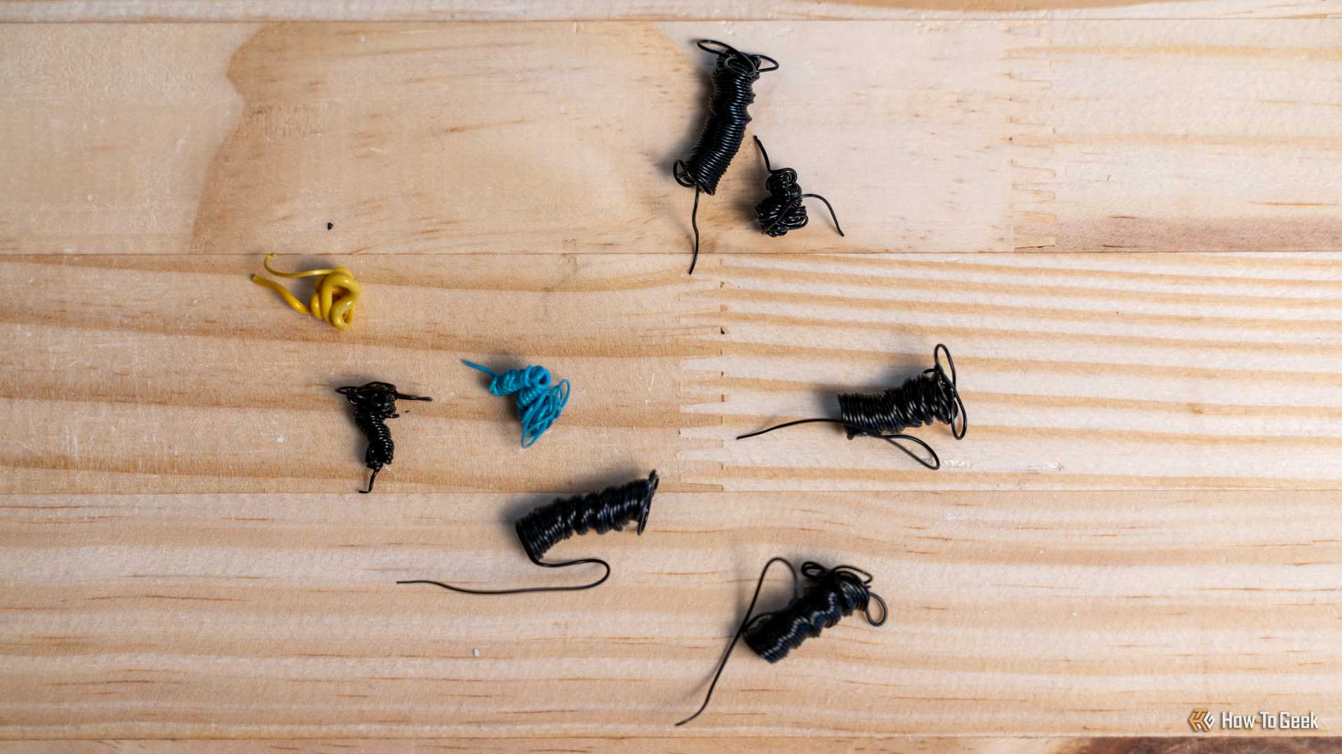 3D printer "poop" or filament purge sitting on a wooden desk.