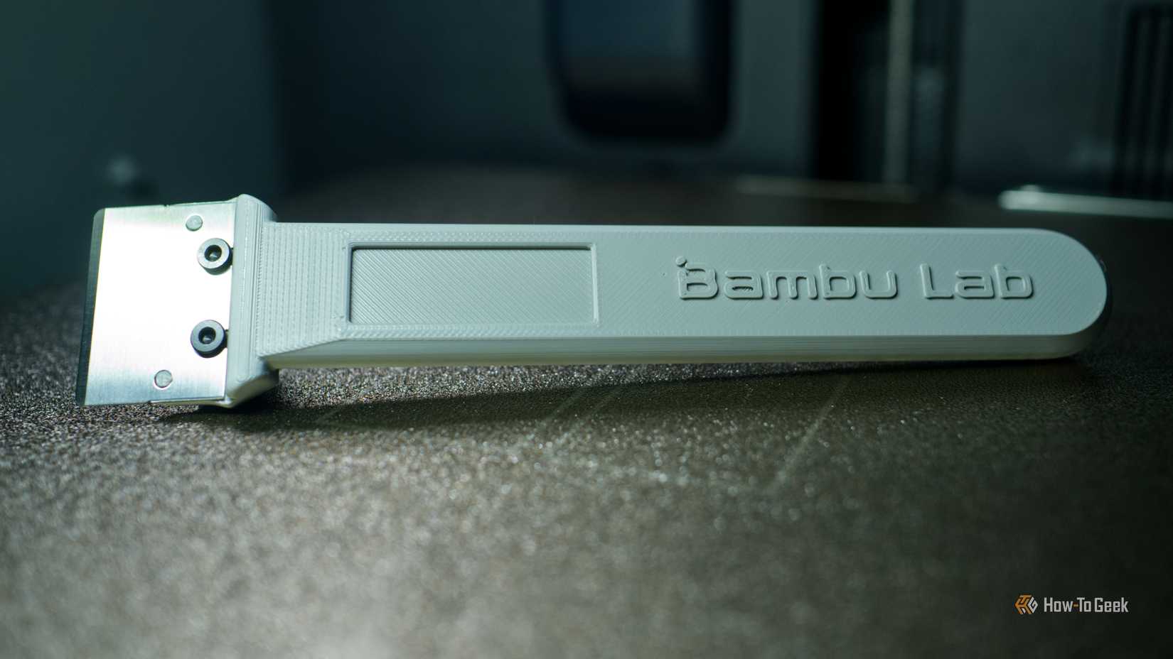 Bambu Lab embossed build plate scraper in a 3D printer.