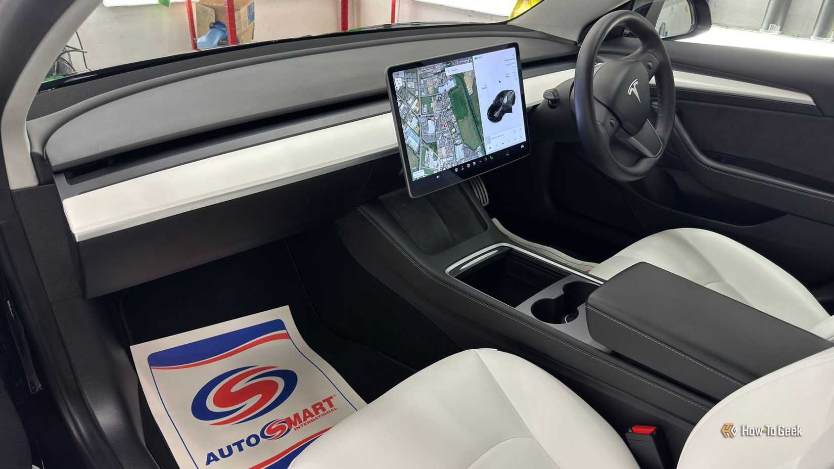 Shot inside the cabin of a 2021 Tesla Model 3 Performance, showing the white interior and infotainment screen.