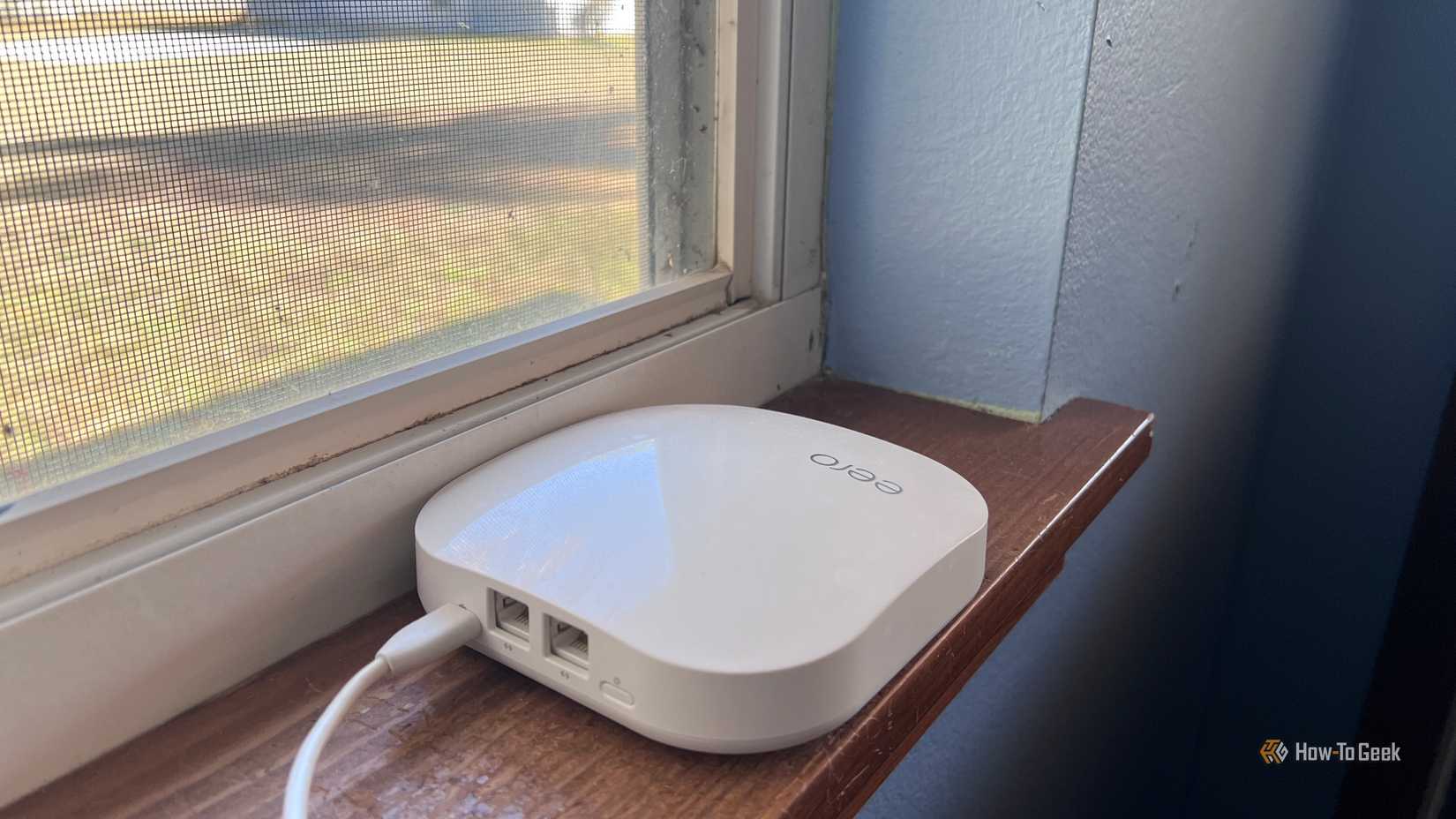 AN eero mesh node sitting on a Window sill to remove obstructions and increase network coverage.