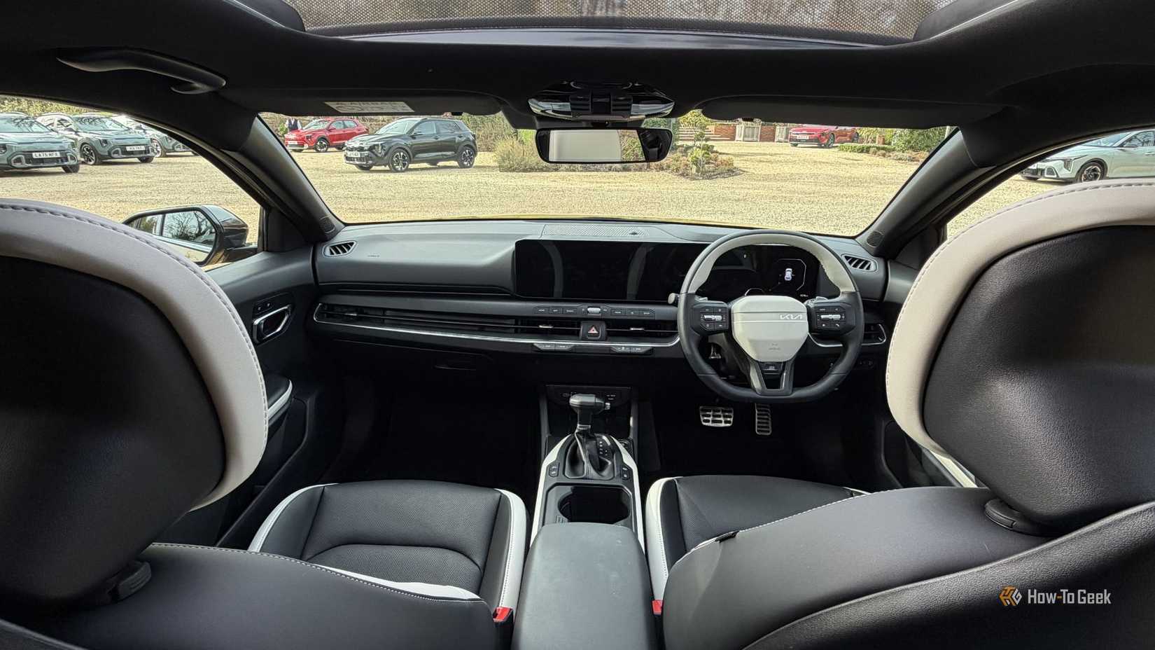 Shot inside the cabin of a 2026 Kia K4 Hatchback, showing the front seats and dashboard.