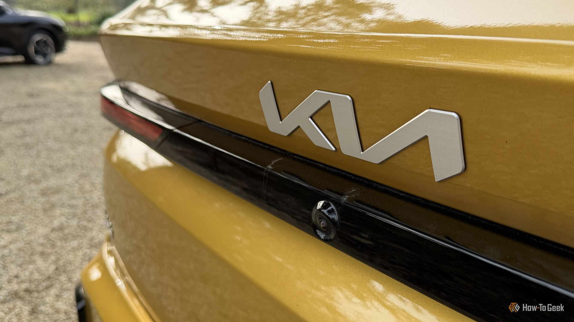 Close-up shot of the Kia badging on the trunk lid of a yellow 2026 Kia K4 Hatchback.