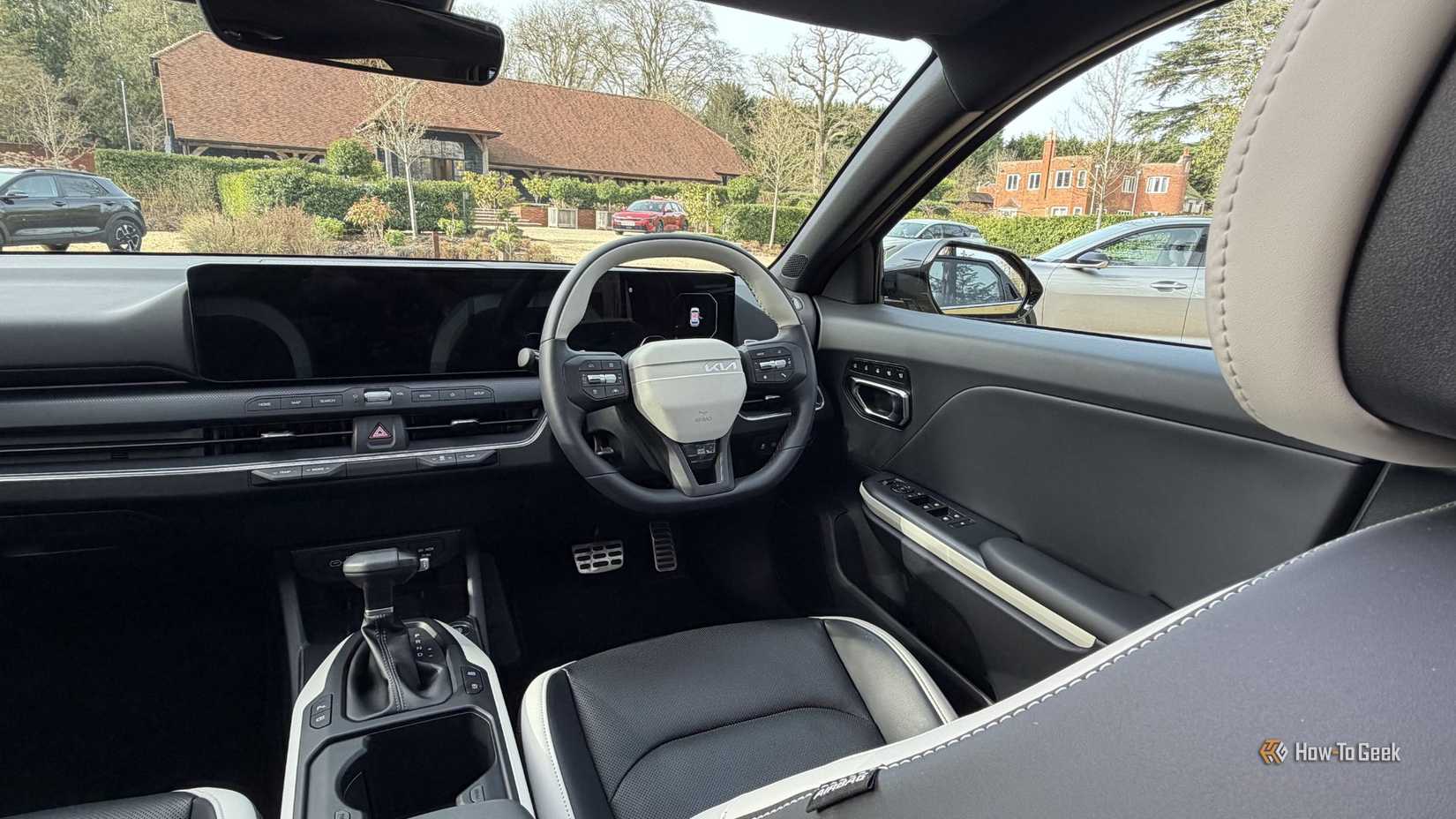 Shot of the driver's seat and panoramic digital display in a 2026 Kia K4 Hatchback.