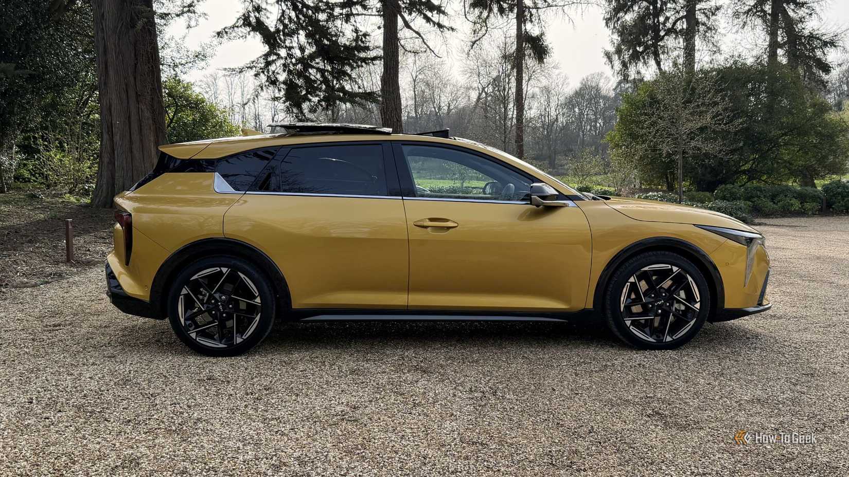 Static side profile shot of a yellow 2026 Kia K4 Hatchback.