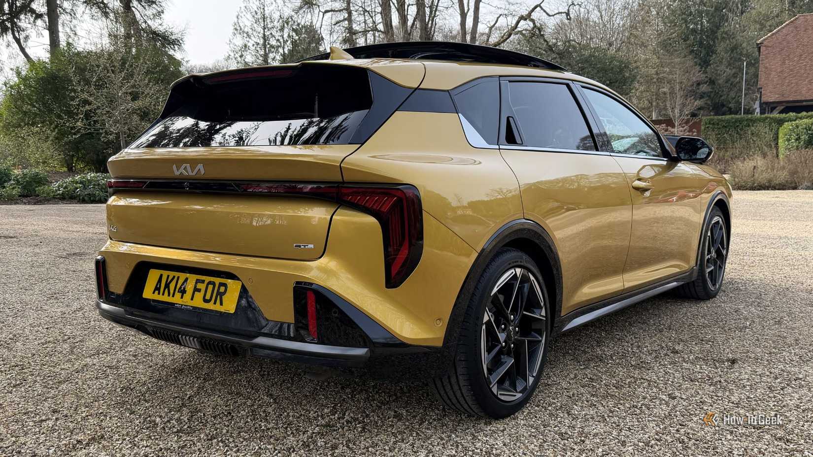 Static rear 3/4 shot of a yellow 2026 Kia K4 Hatchback.