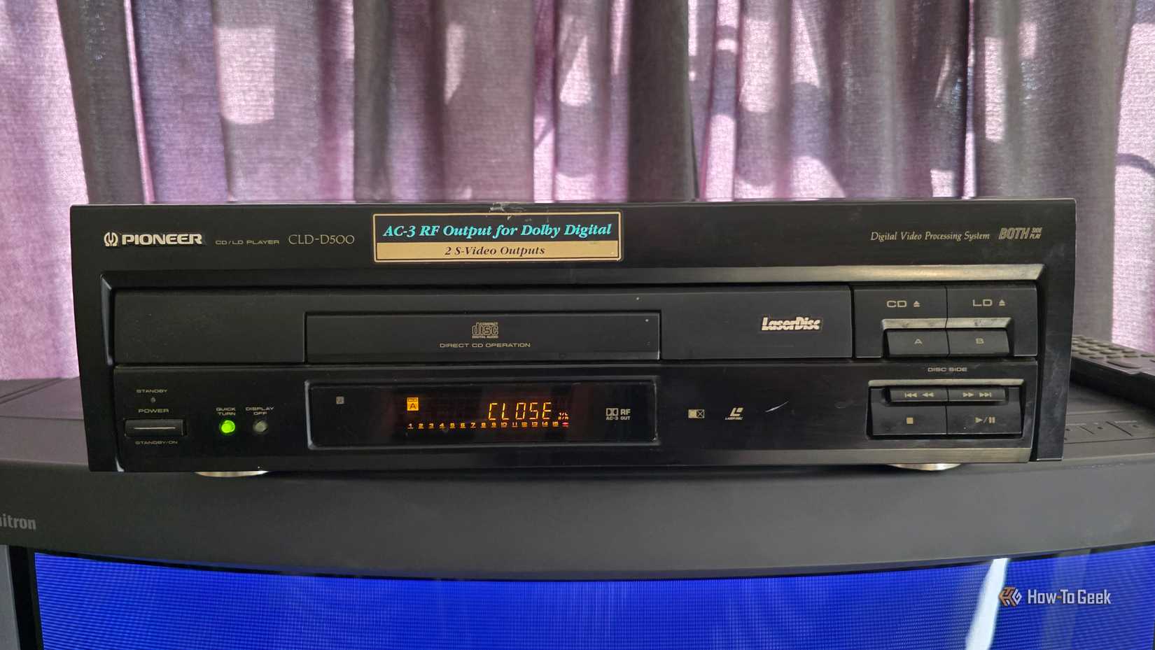 A LaserDisc player sits on top of a TV.