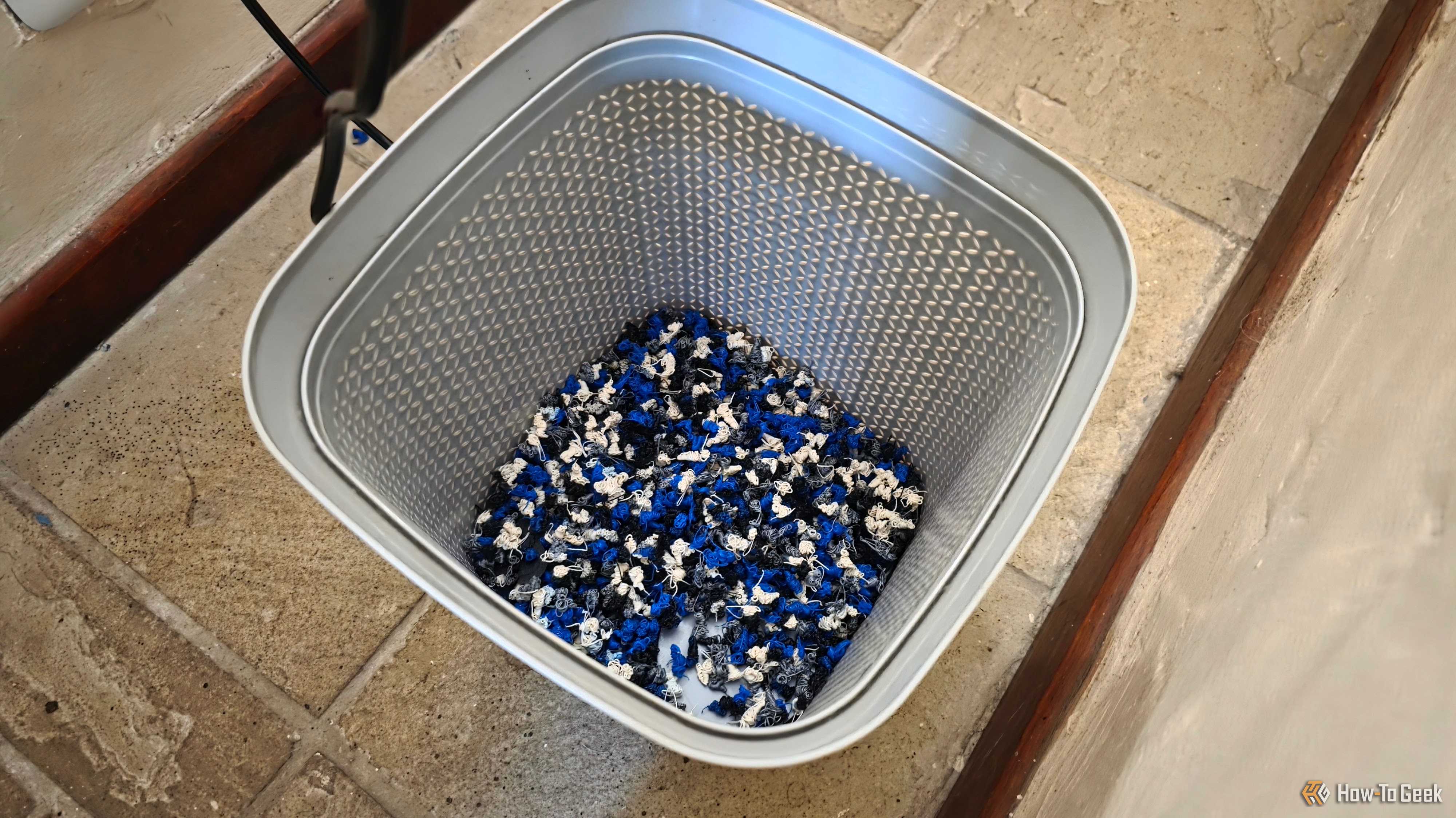 A plastic wastepaper basket full of PLA purges.