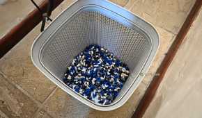 A plastic wastepaper basket full of PLA purges.