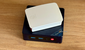 A Raspberry Pi in a case lying on top of a Beelink Mini S12 Pro mini PC.