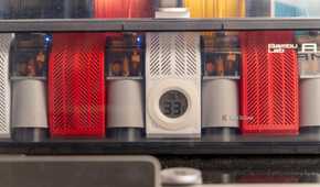 The Bambu Lab AMS unit with filament and desiccant in it showing a hygrometer for humidity and moisture percentage.