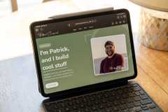 A personal website built with AI and hosted on CloudFlare pages open on an iPad Pro sitting on a wooden table.