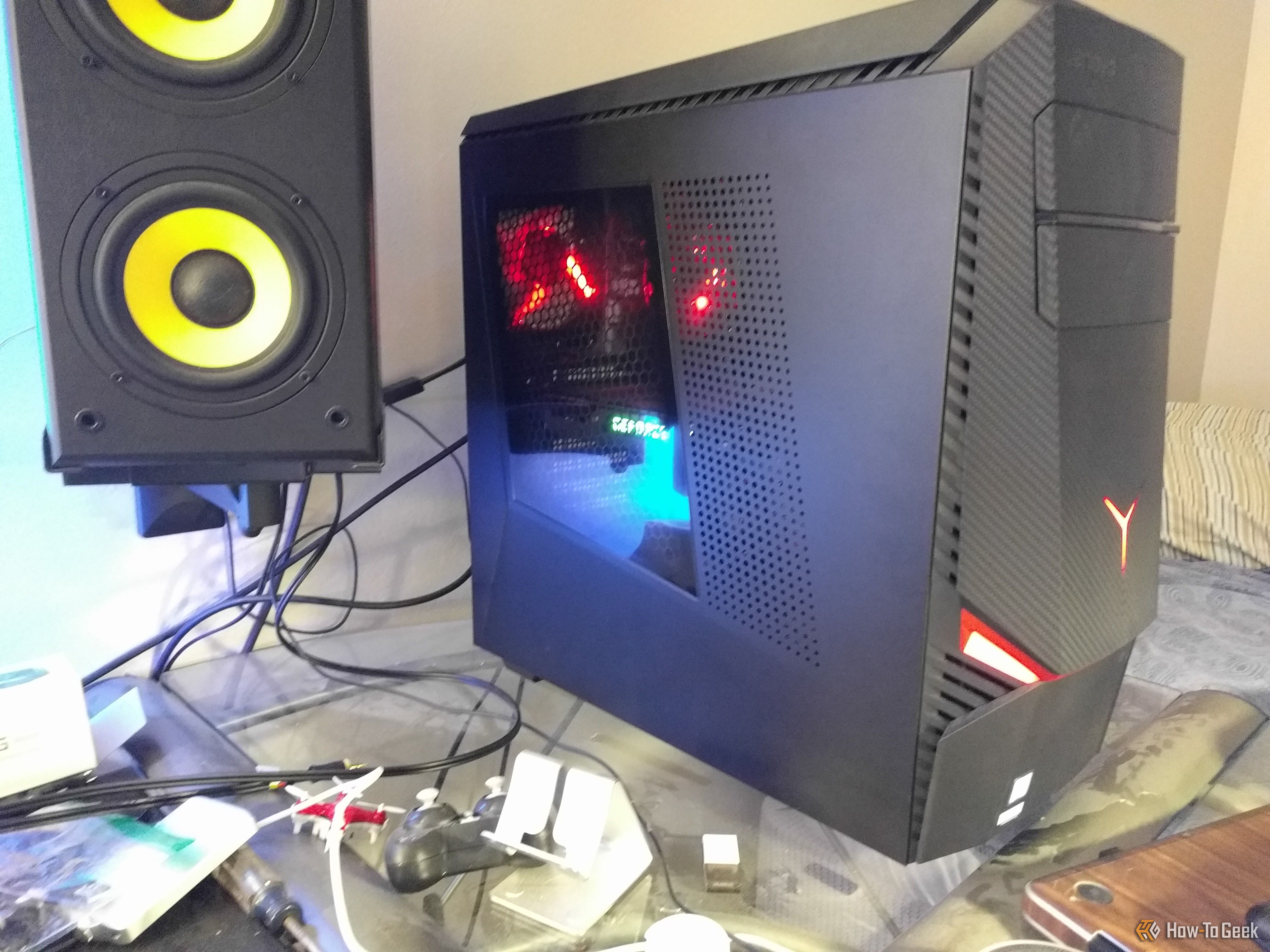 An old desktop computer sitting on a glass desk with wires everywhere.