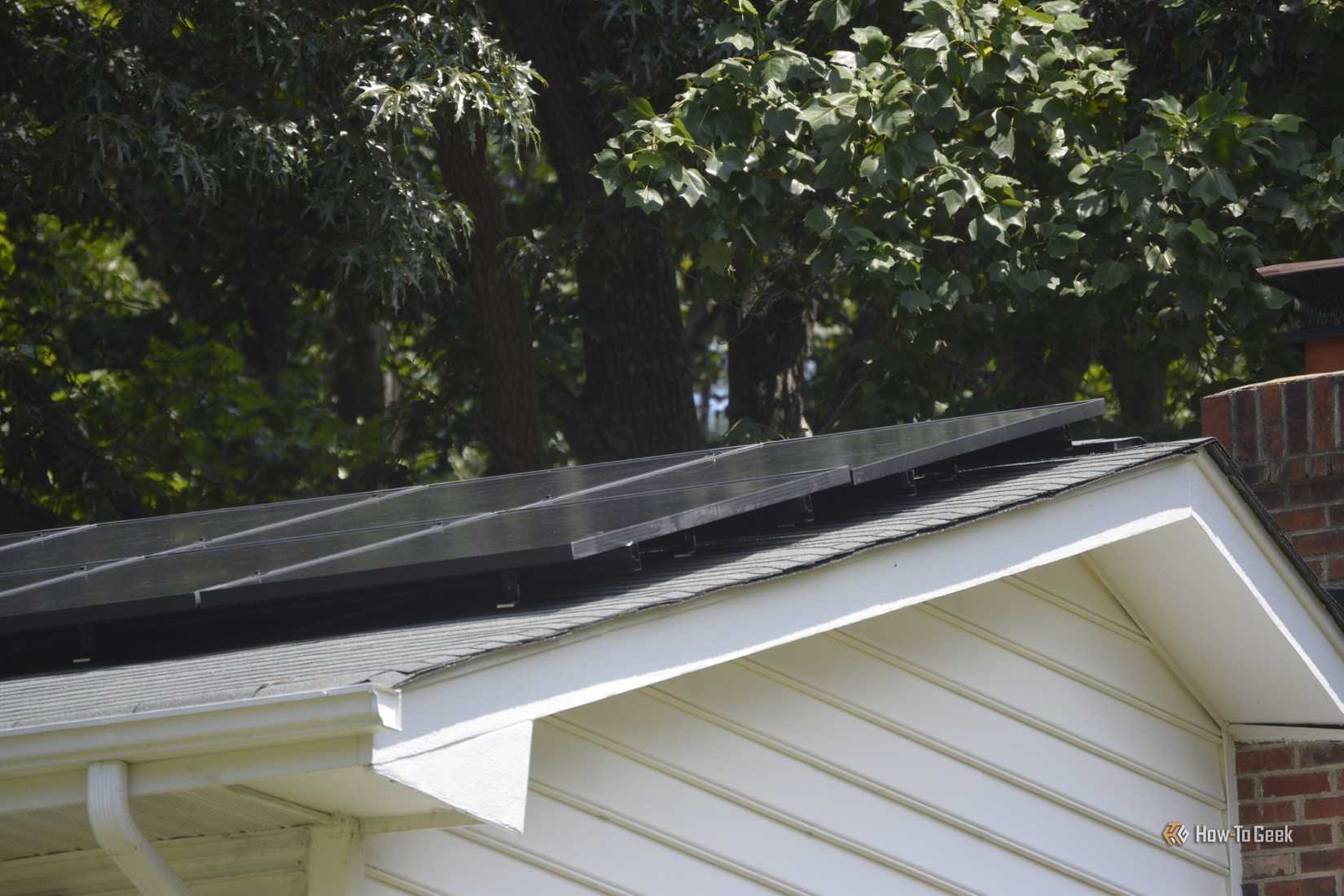 Close-up of solar panels on the roof of a white house.