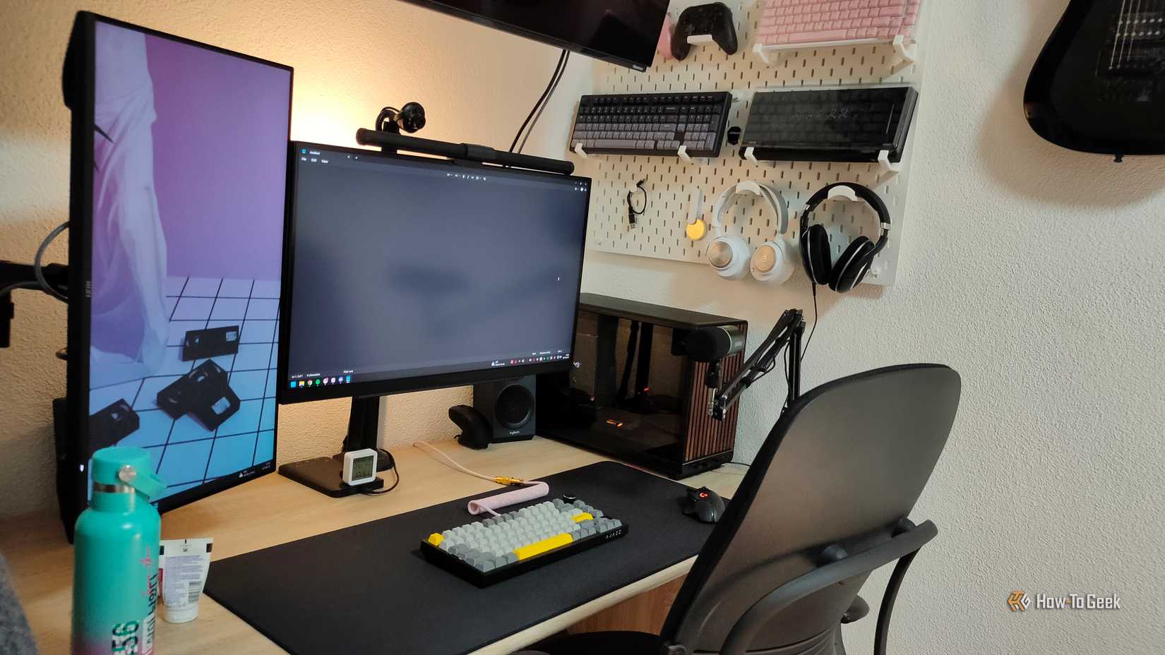 Desk setup with monitors, TV, and pegboard (1)