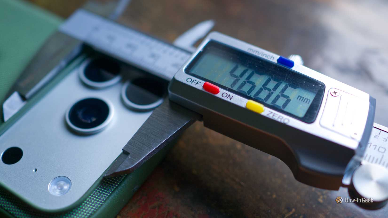 Digital caliper measuring the back of an iPhone case.
