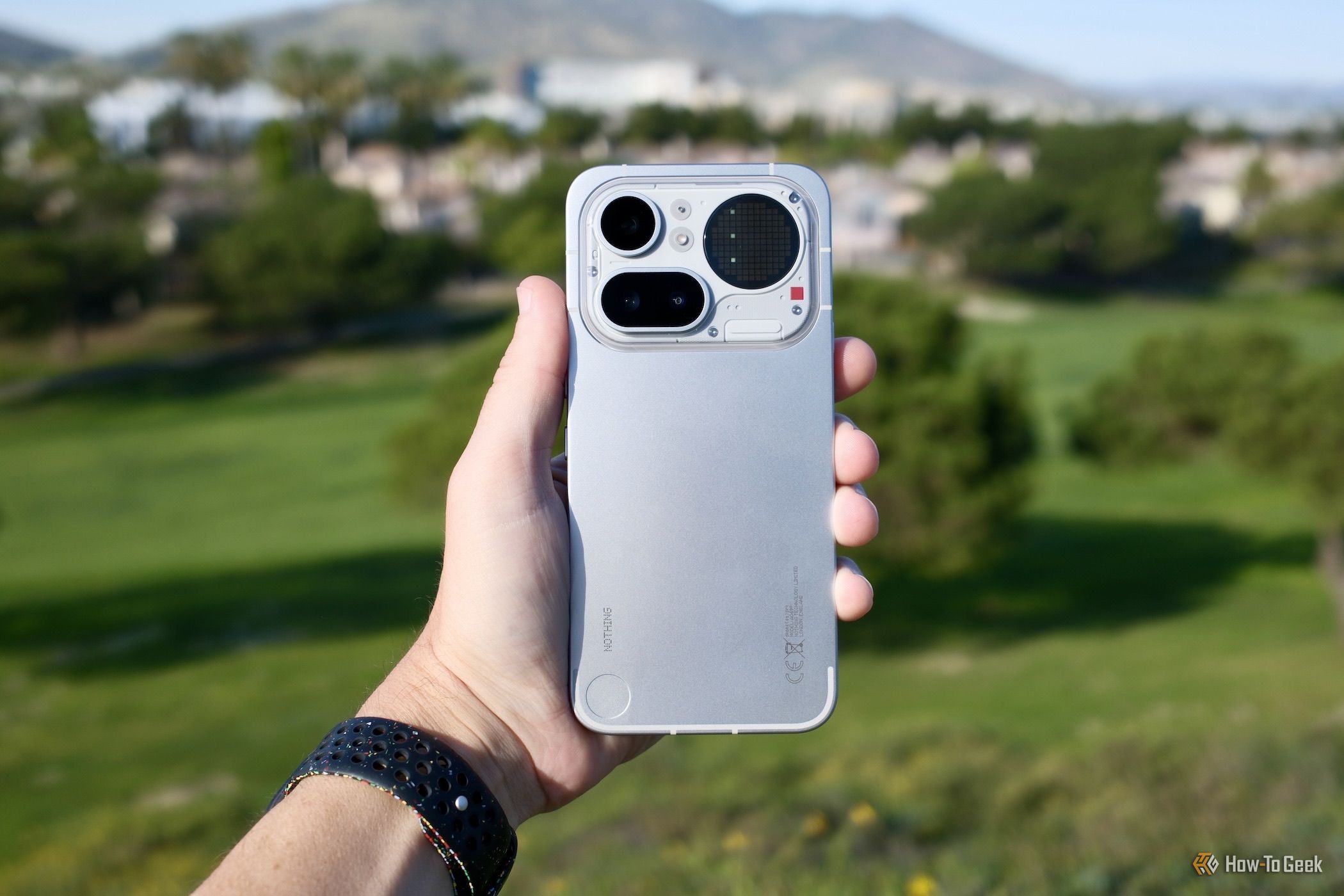 Nothing Phone 4a Pro held in hand outside.