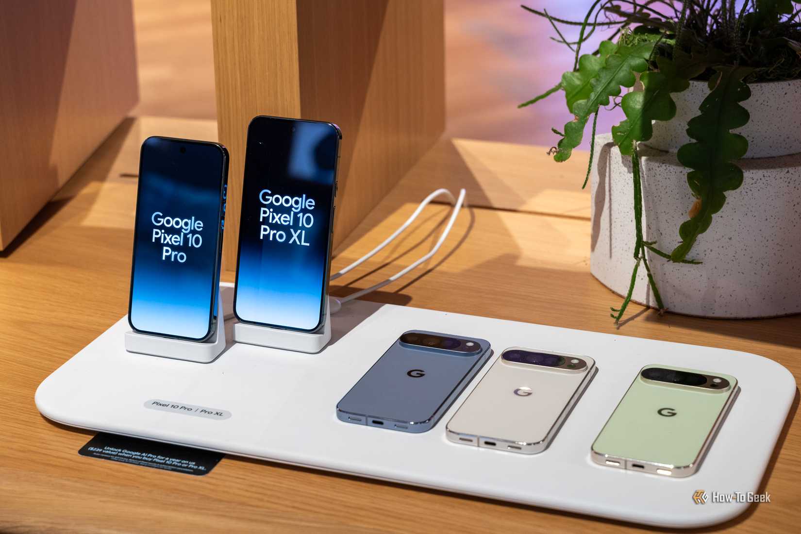 Google Pixel 10 Pro and Pixel 10 Pro XL phones displayed on a demo table with three color options.