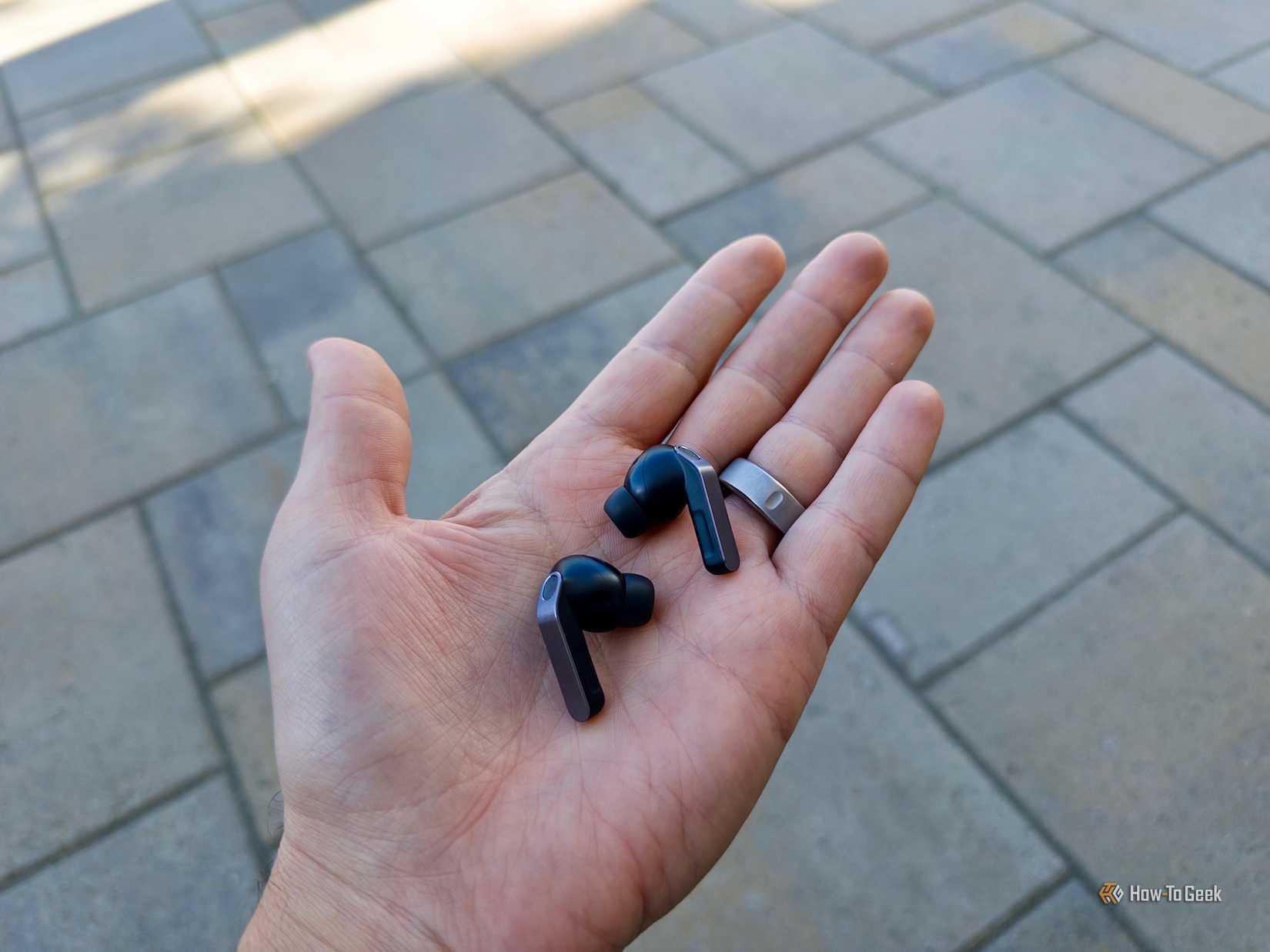 The Samsung Glaxay Buds4 Pro in black, held in hand.
