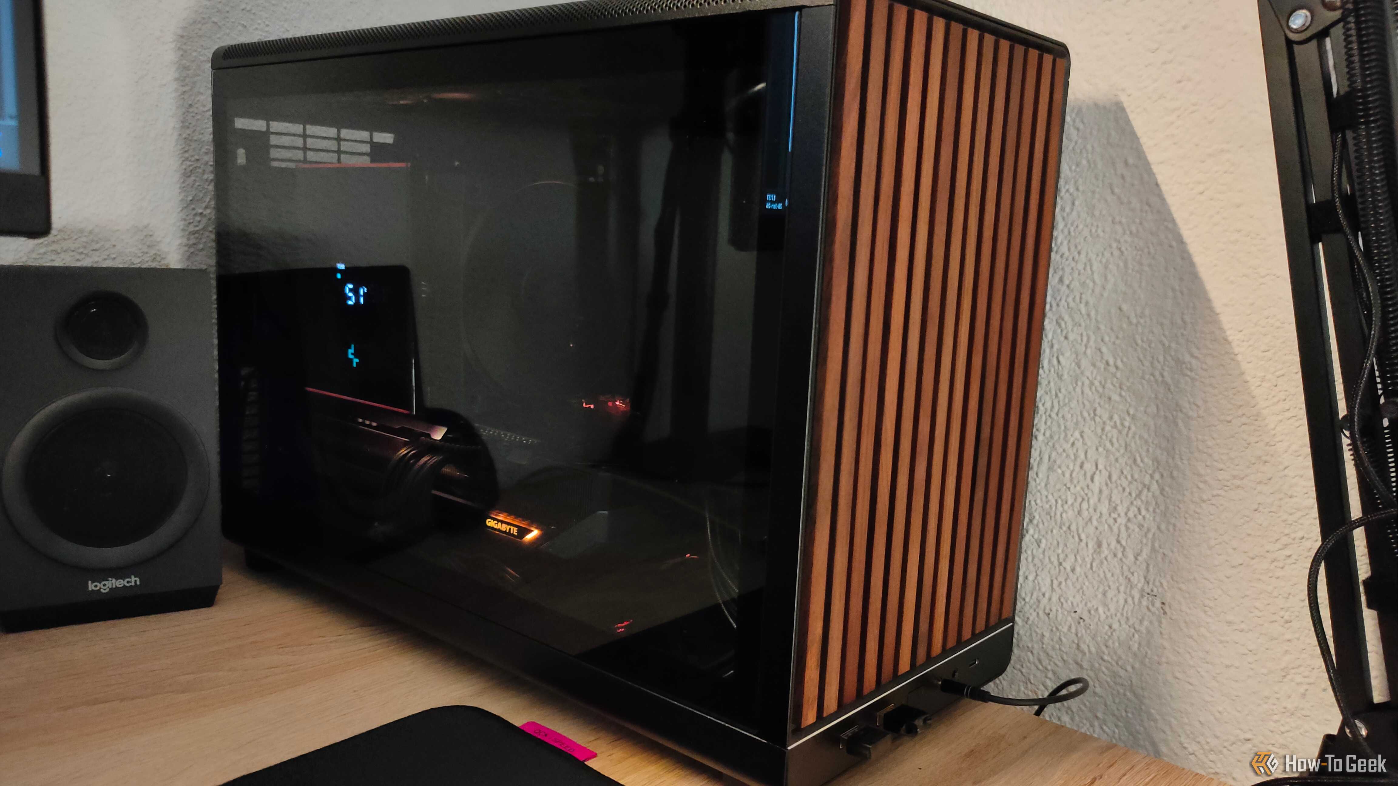An ITX PC tower stands next to a PC speaker.