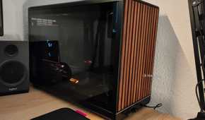 An ITX PC tower stands next to a PC speaker.