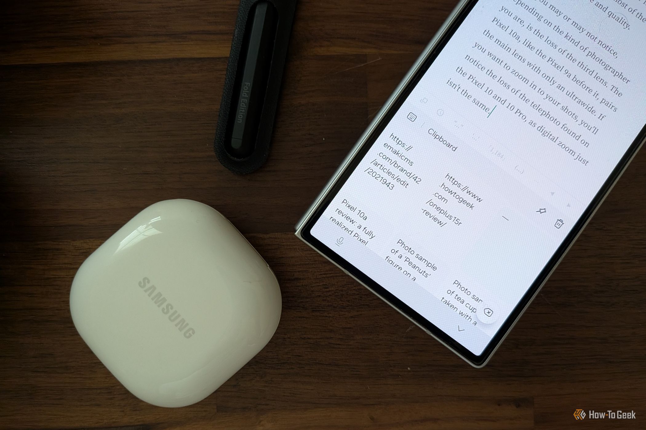 Keyboard clipboard on a Samsung Galaxy Z Fold 6 next to an S Pen and headphones.