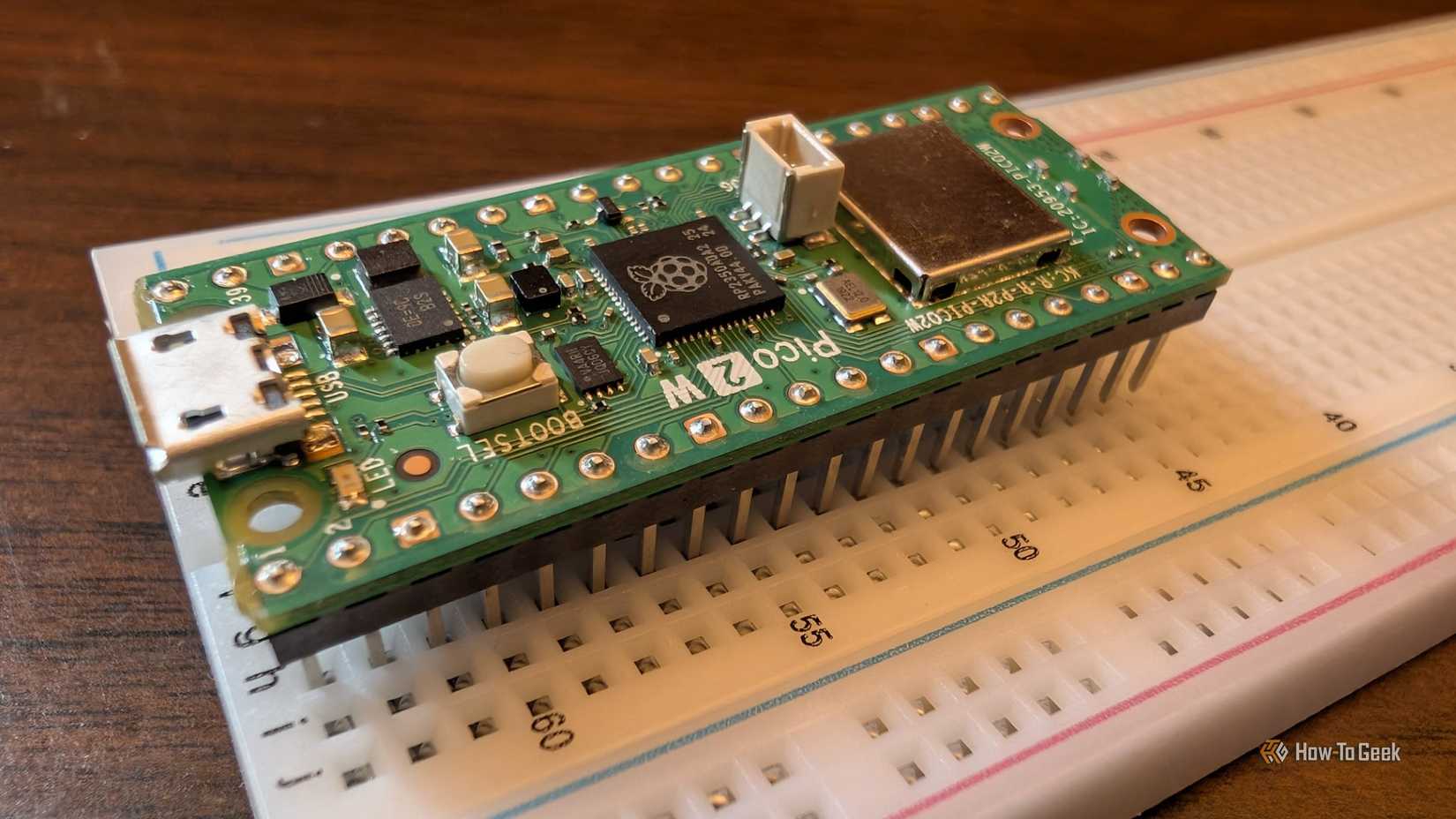 The Pico 2 W barely attached to a breadboard.