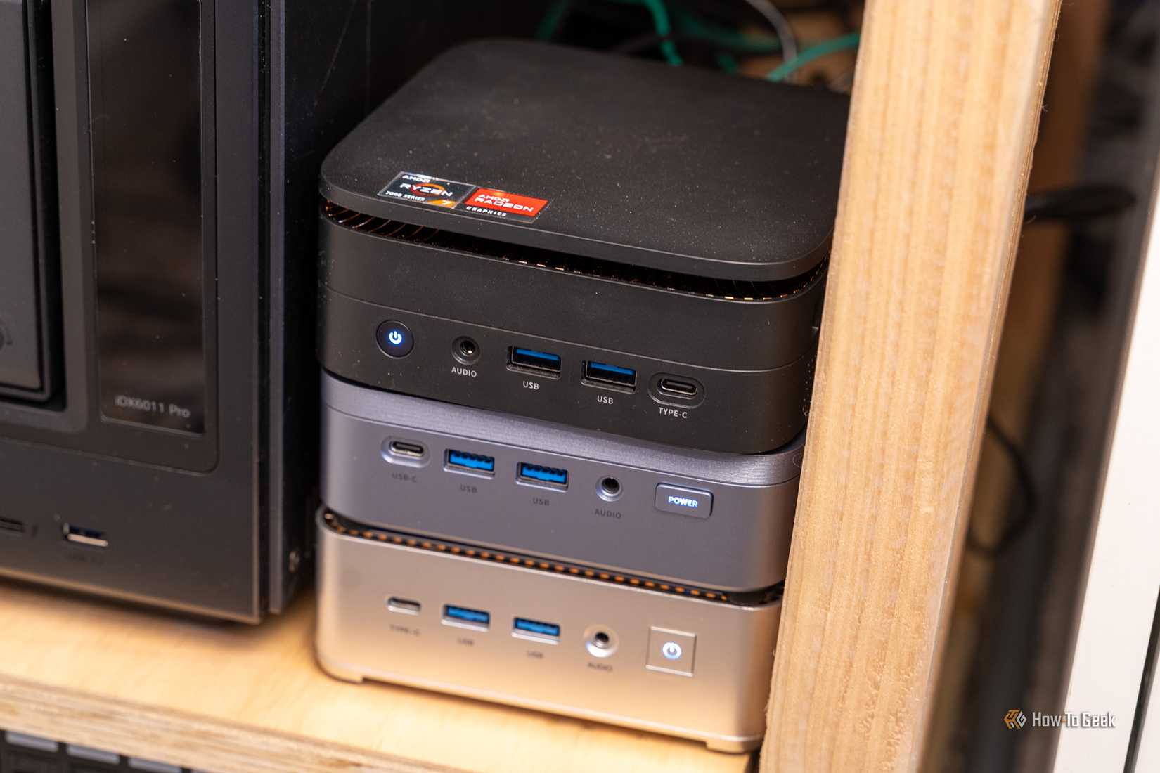 Three mini PCs stacked on top of each other in a homelab.
