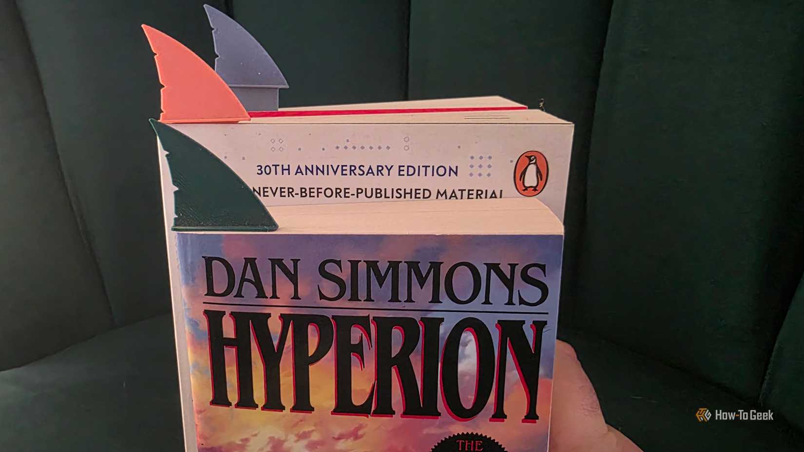 Several books with shark fin bookmarks in different colors in them.