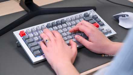Person typing on OnePlus 81 Pro keyboard with rainbow backlight.