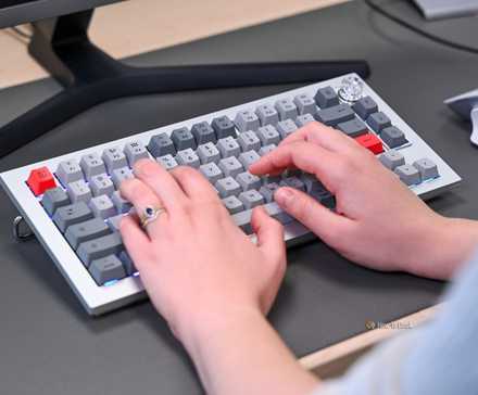 Person typing on the OnePlus Keyboard 81 Pro with rainbow backlighting.