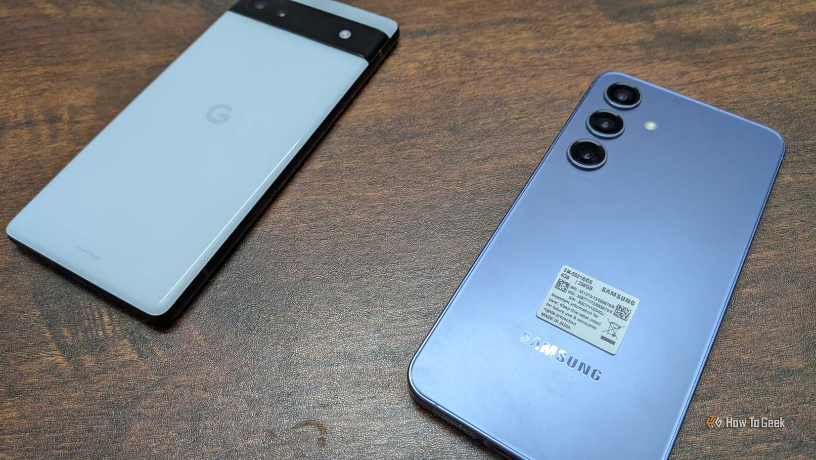 A pixel 6a and a Samsung Galaxy S24 side by side on a wooden table.