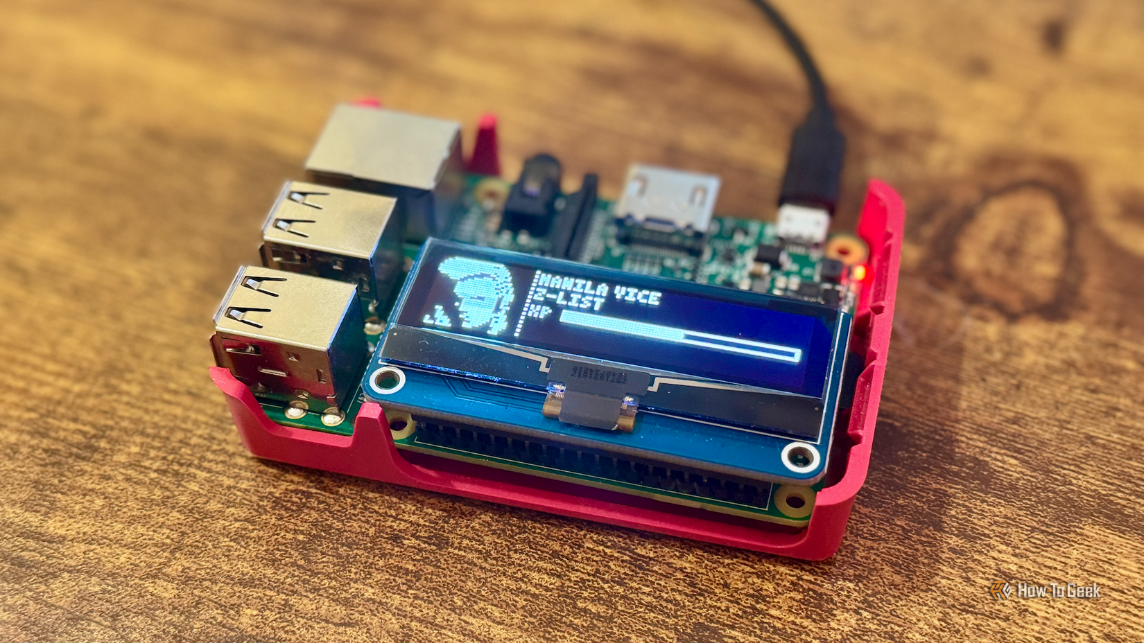 A Raspberry Pi 3B+ with an OLED screen displaying a Tamagotchi game.