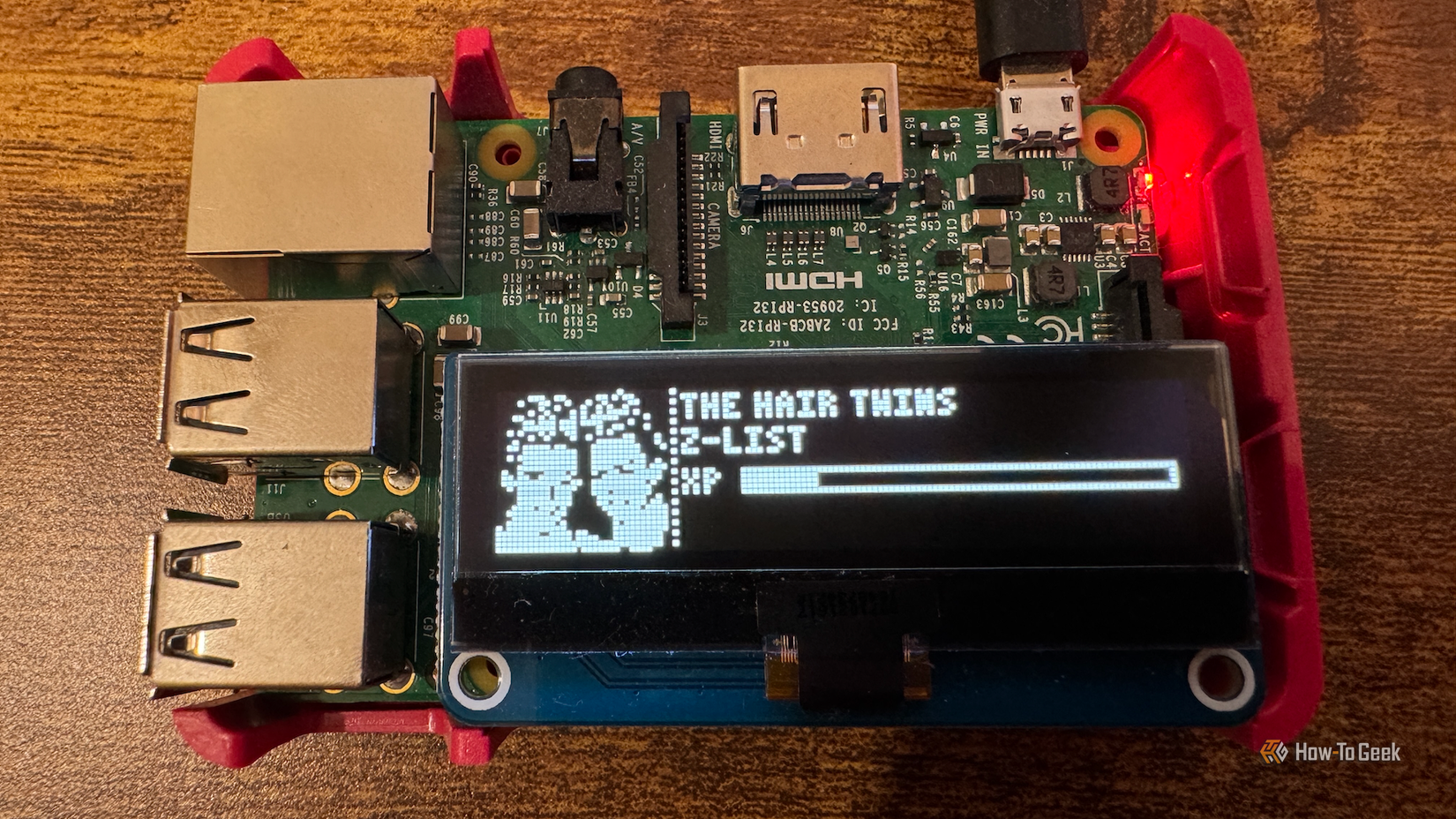 A Raspberry Pi with an OLED screen displaying a Z-list Tamagotchi character.