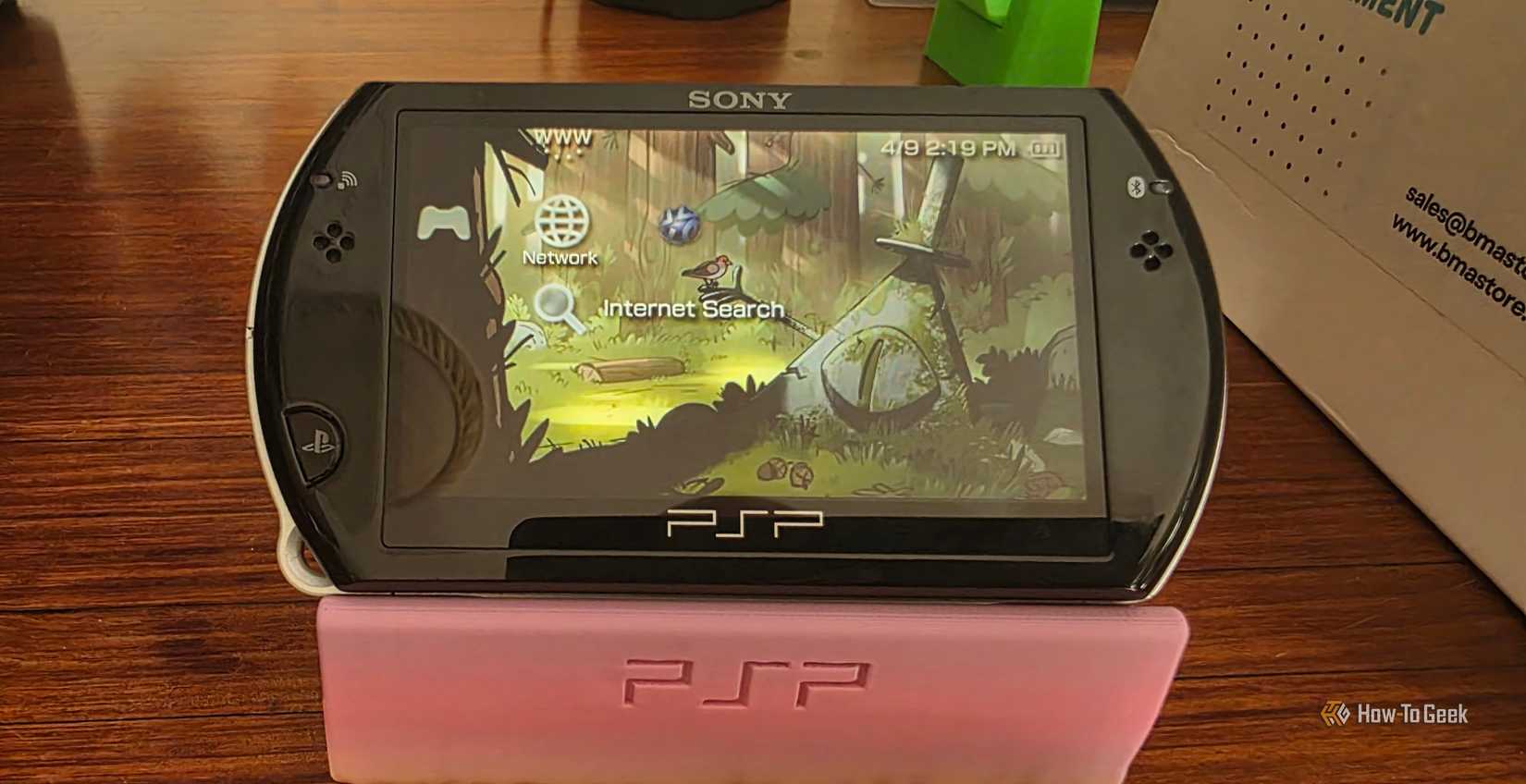 A Sony PSP Go sits atop a 3D-printed stand.