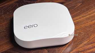 An image of a white eero Mesh Wi-Fi router on a walnut tabletop.