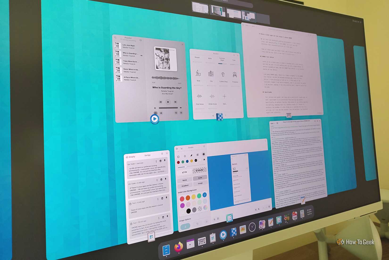 Apps open in the GNOME Activity Overview on a desktop monitor.