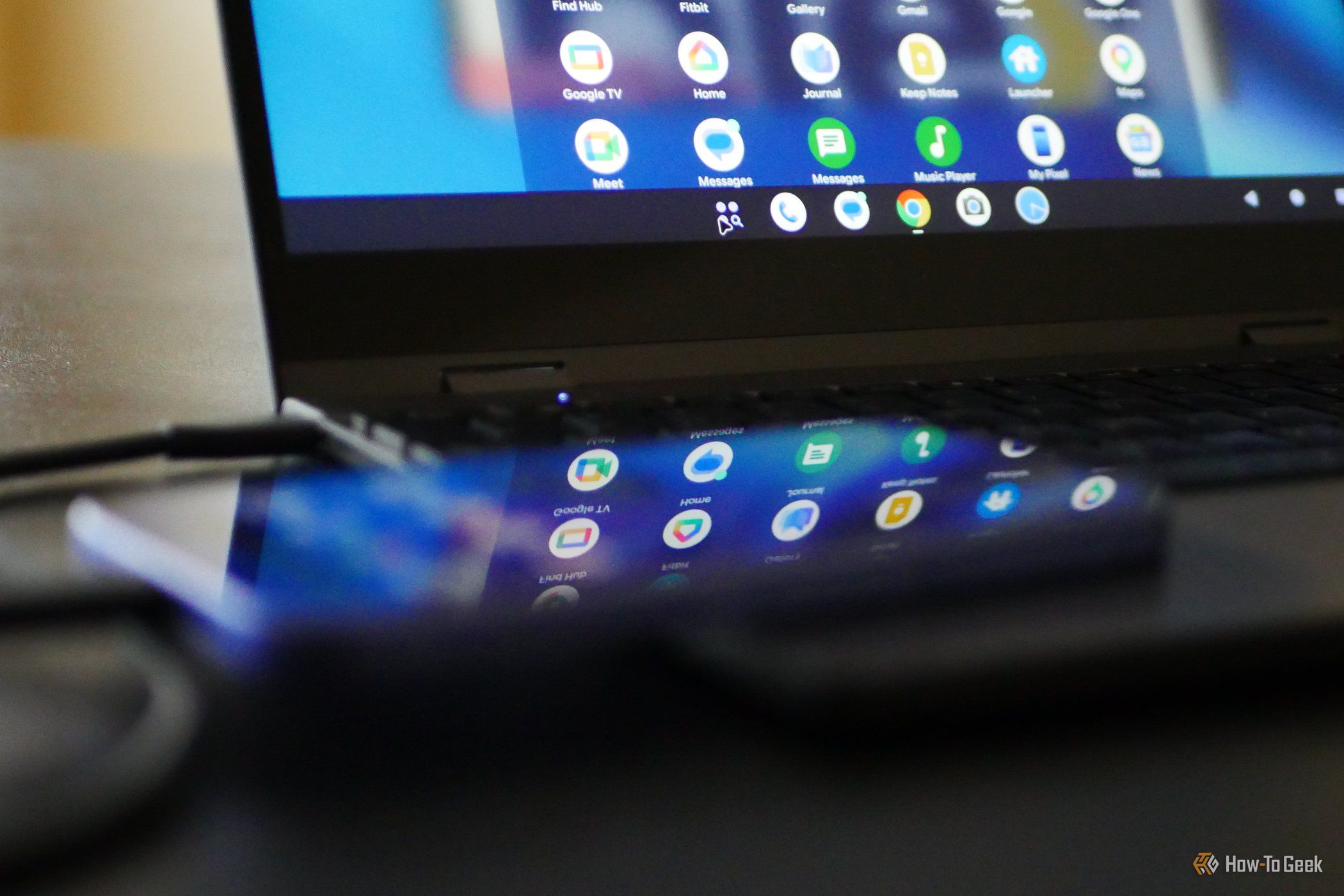 Google Pixel 10a with Pixel Desktop displayed on a lapdock in the background.