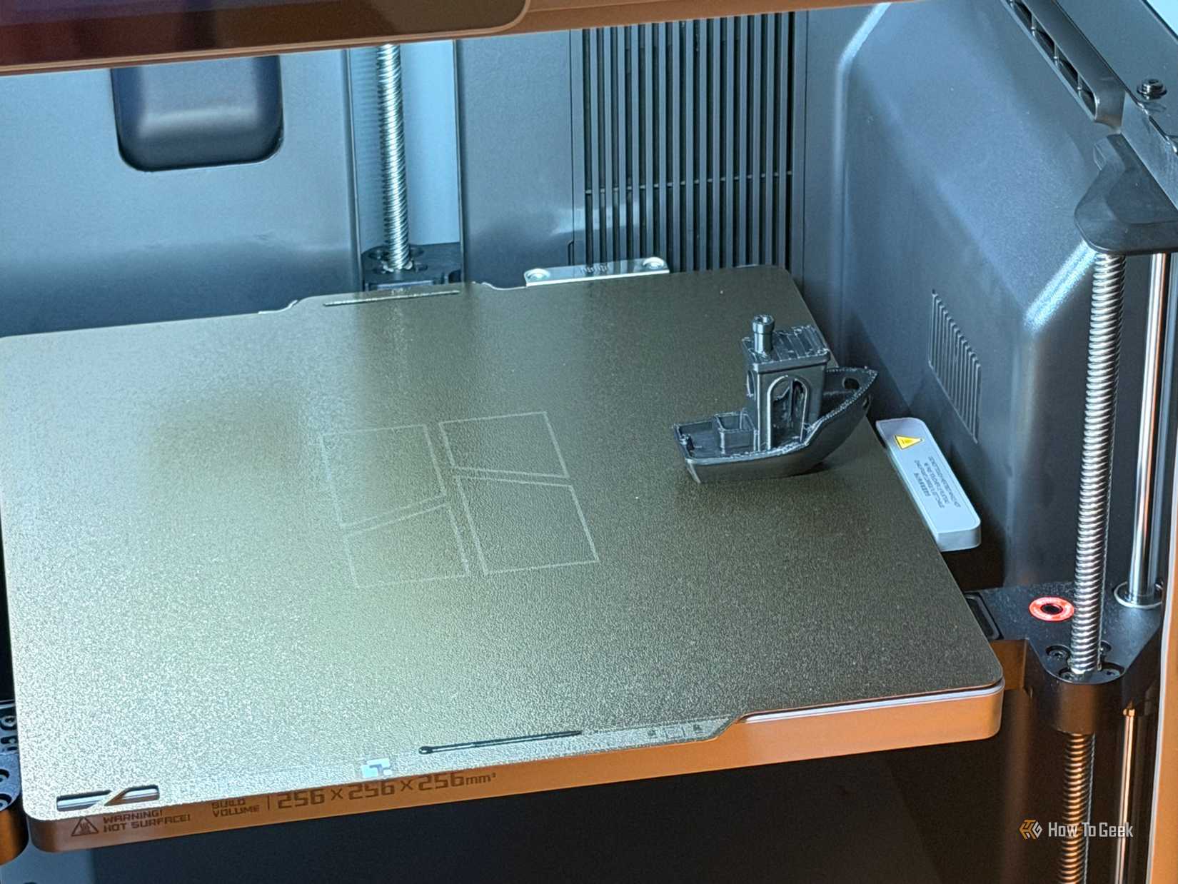 Benchy sitting on the build board of the Bambu Lab P2S, the entire build board is visible.