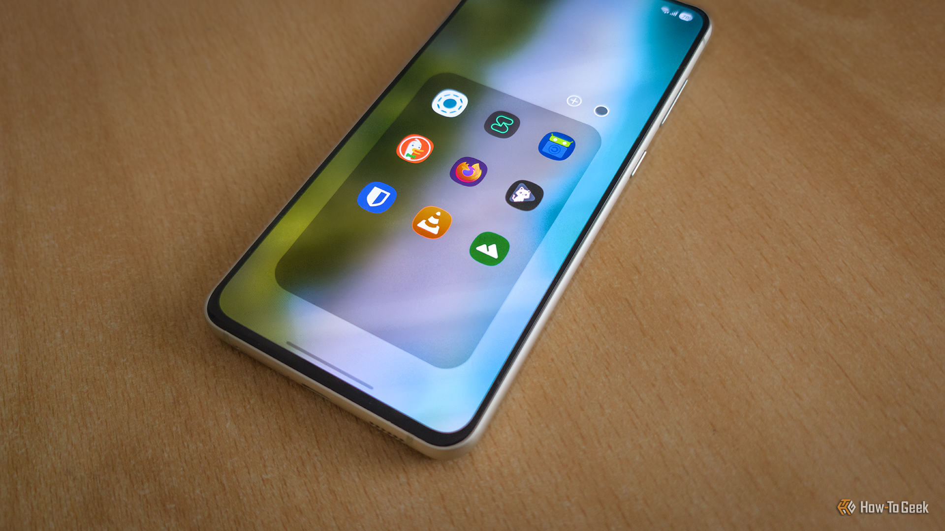 A Samsung Galaxy S21 FE lying on a table displaying a collection of app icons.  