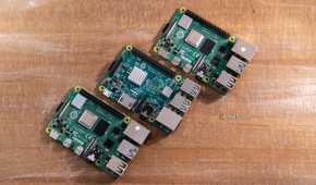 Overhead view of three Raspberry Pi boards arranged on a wooden table.